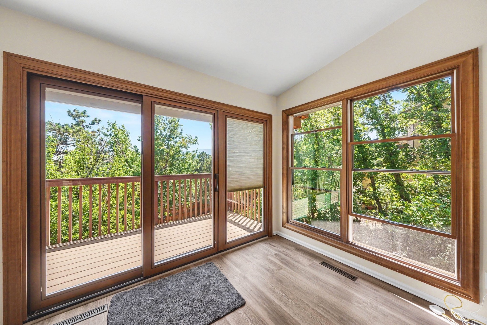 Pella sliding patio door and corner double-hung windows with warm wood interior finish
